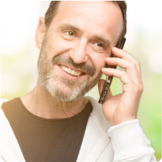 A man smiling and talking on a cell phone